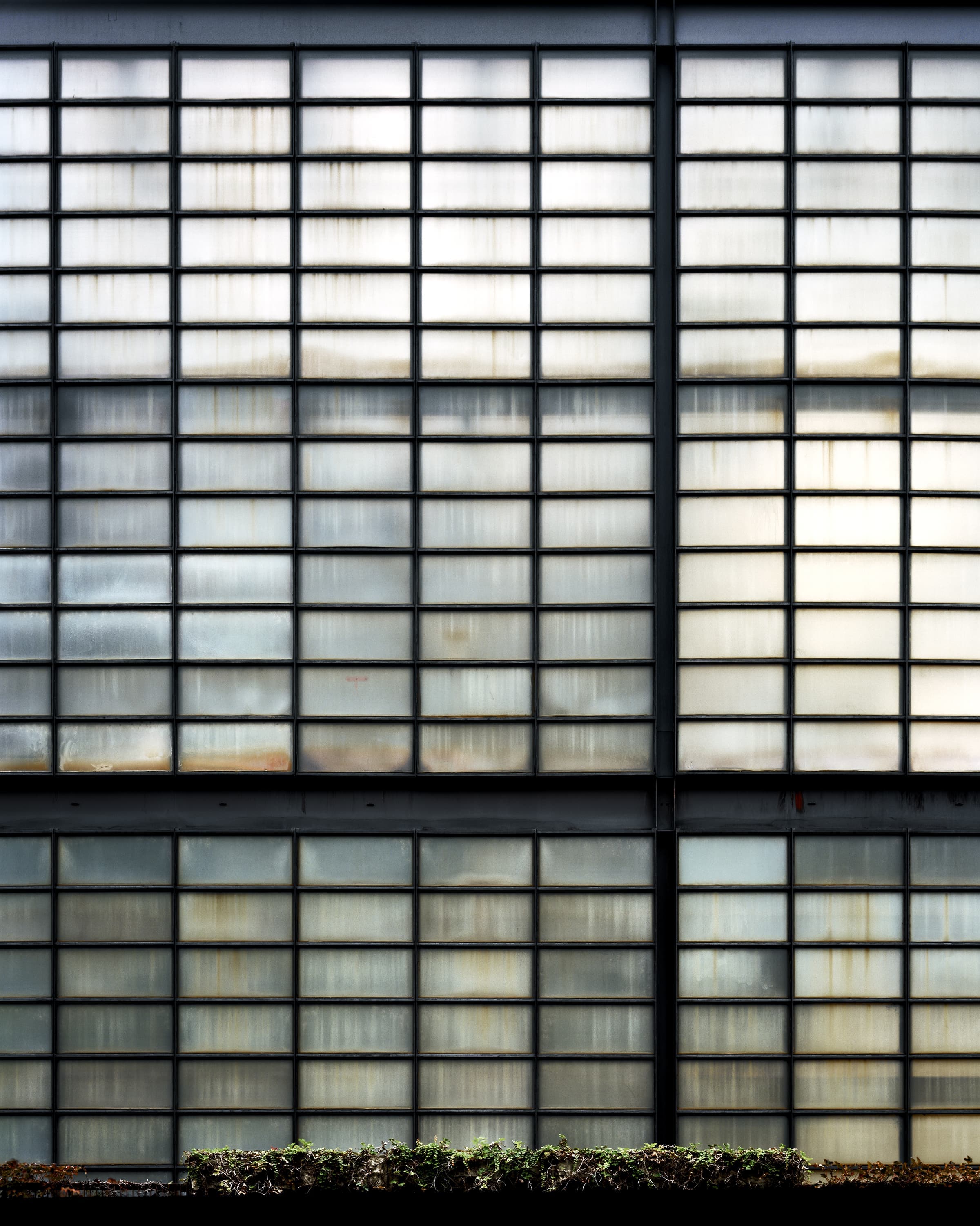 Fogged, tinted, and stained windows on a powerplant designed to look like a modernist building.