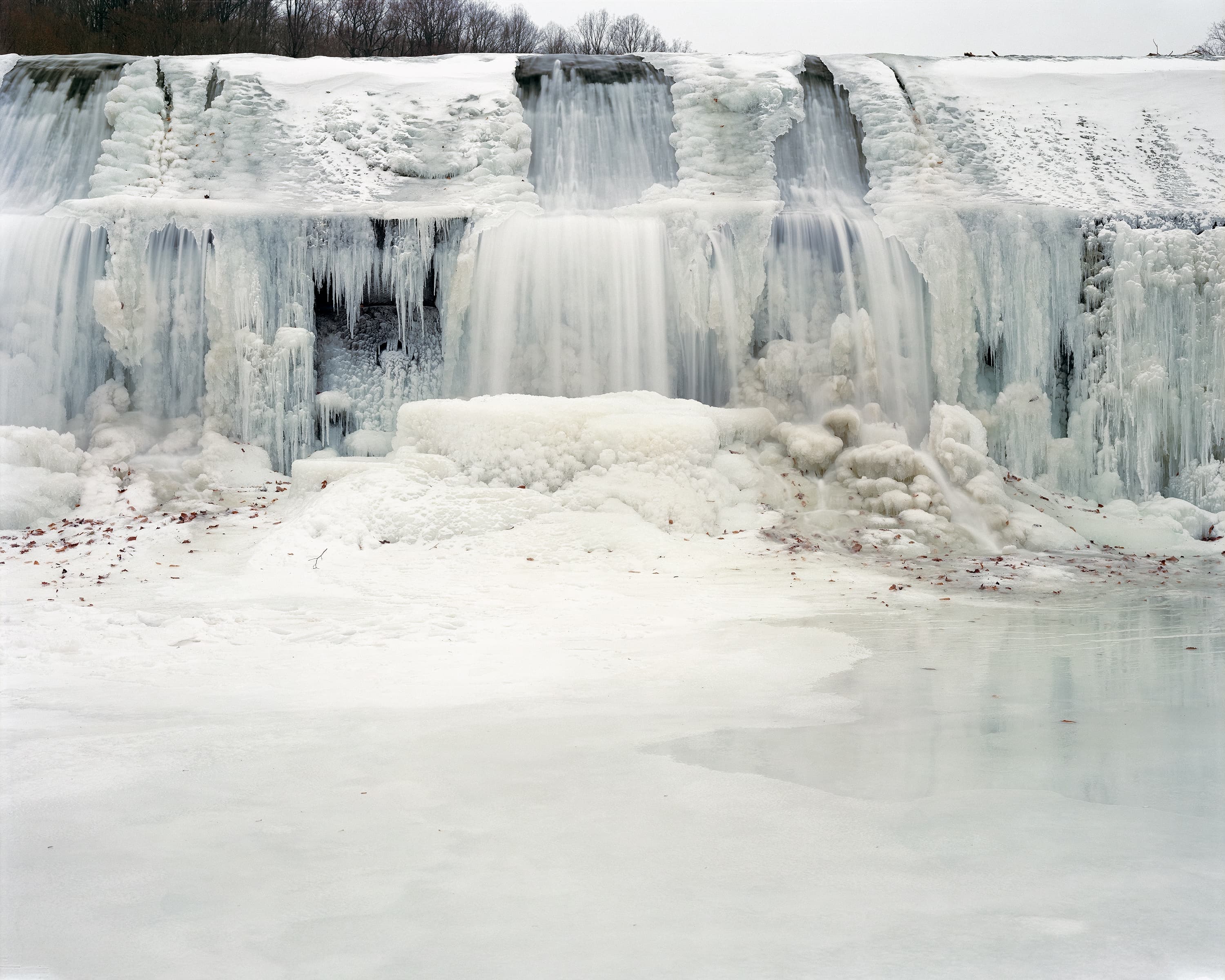 Frozen dam covered in snow and ice.