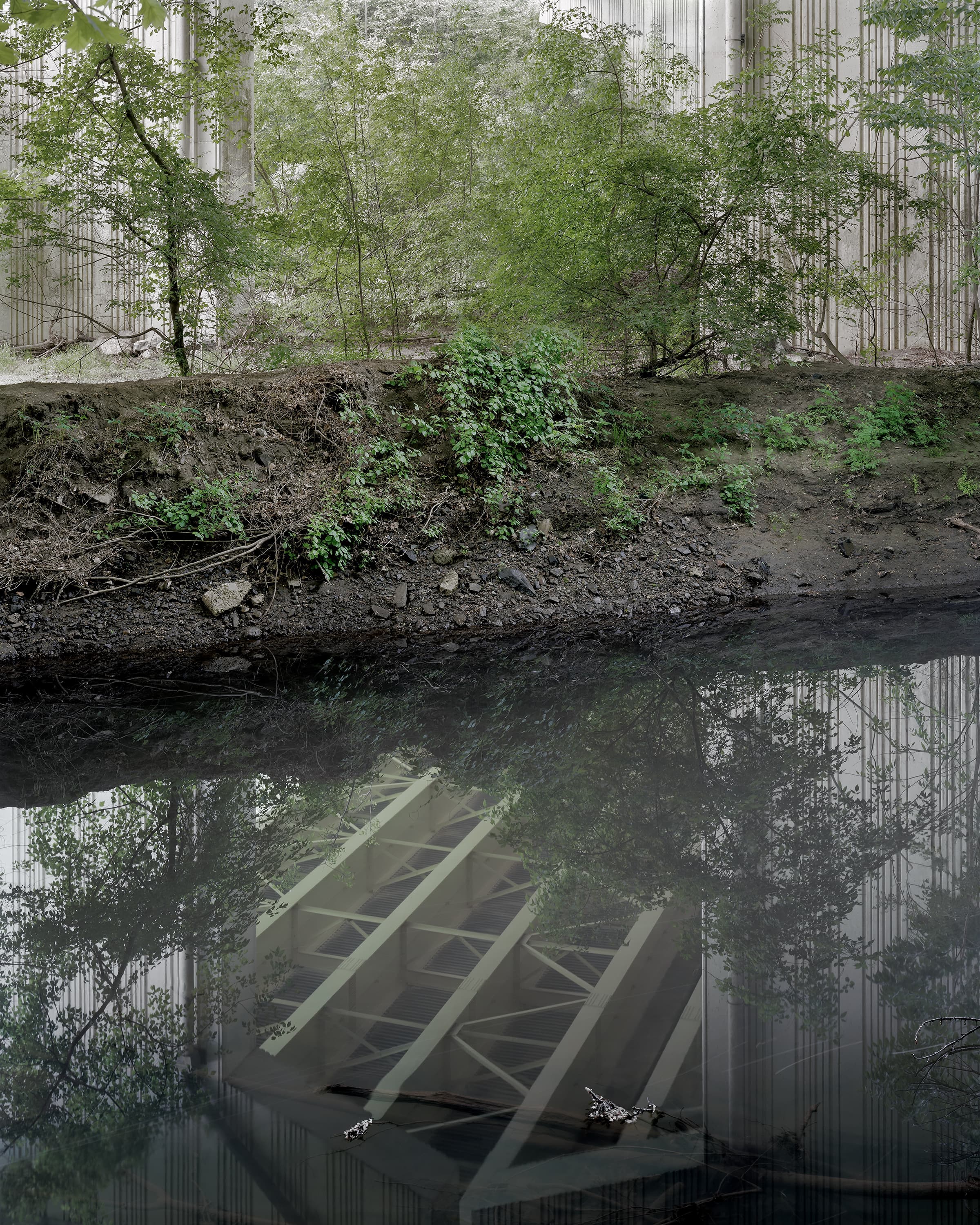 Reflection of the interior roof of a bridge on the water of a stream below.