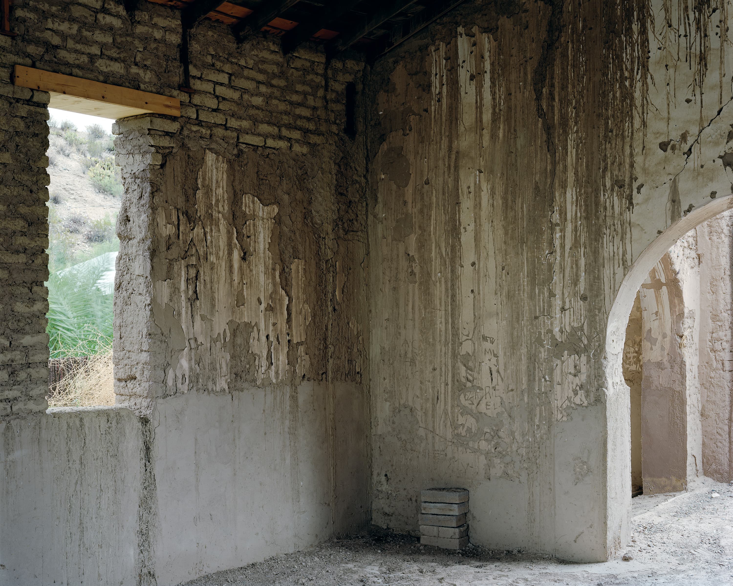 Interior of old adobe church in Ruidosa, Texas, unusual because of the arched doorways. Historic graffiti scratched into the walls.