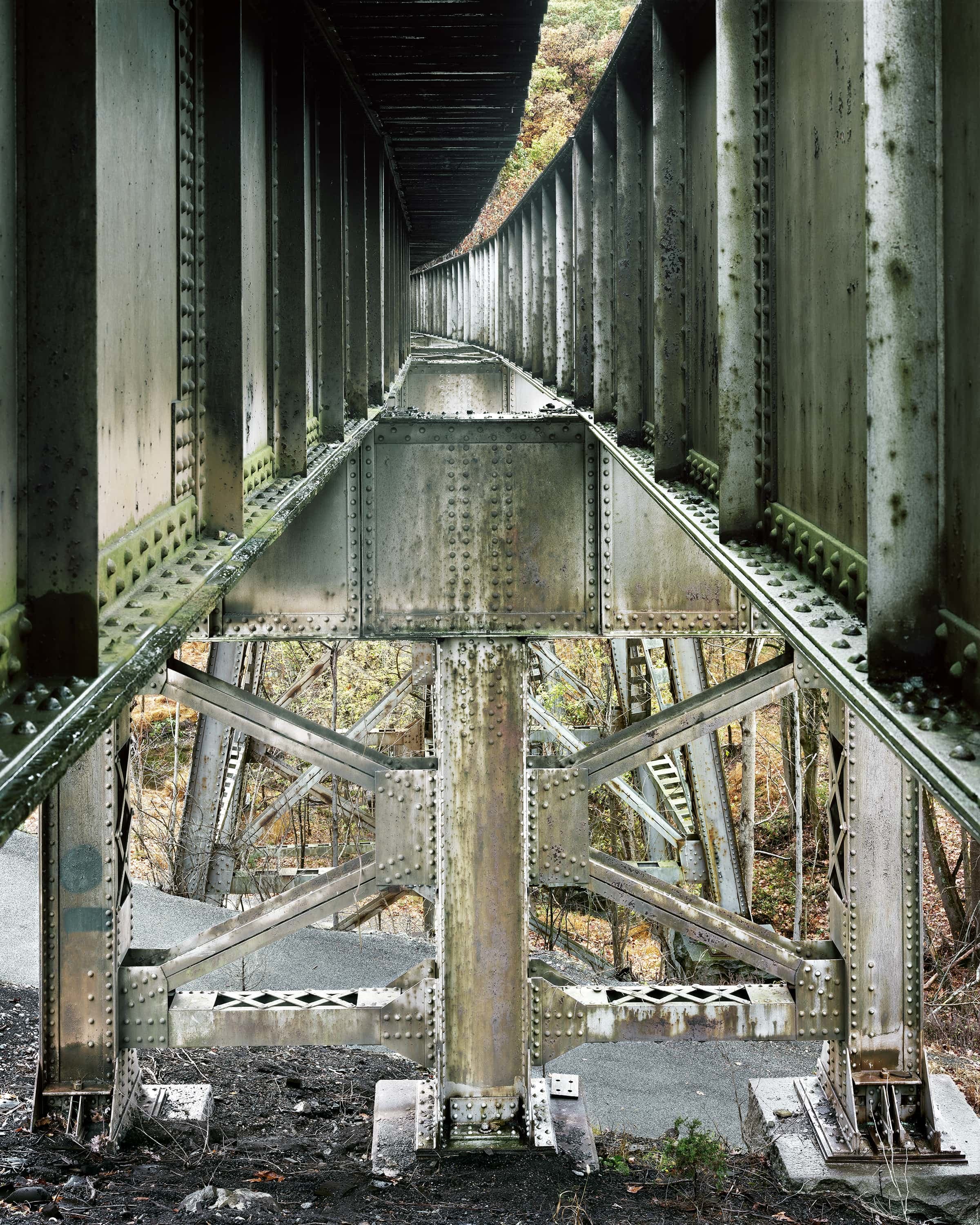 Interior of open deck truss of Western Maryland railway bridge over autumn landscape.