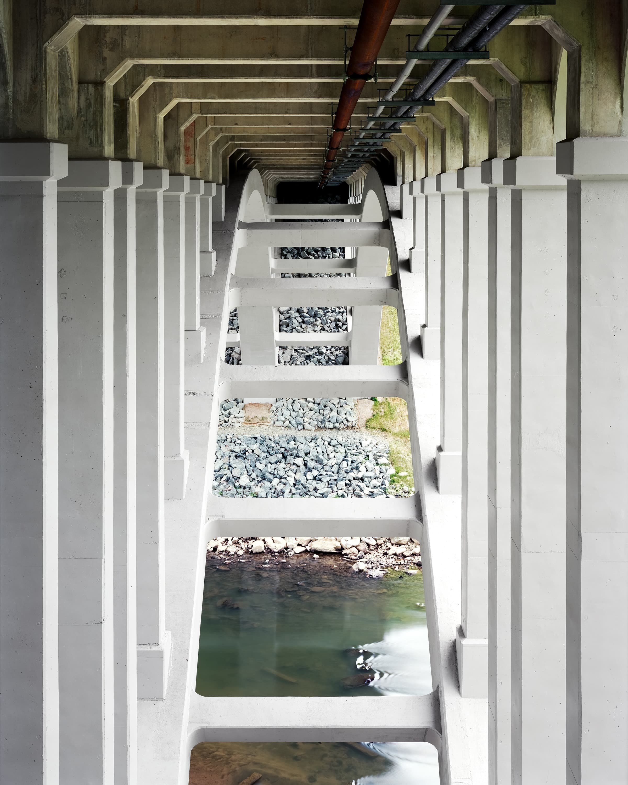 Under concrete arch bridge crossing a quiet section of the river.