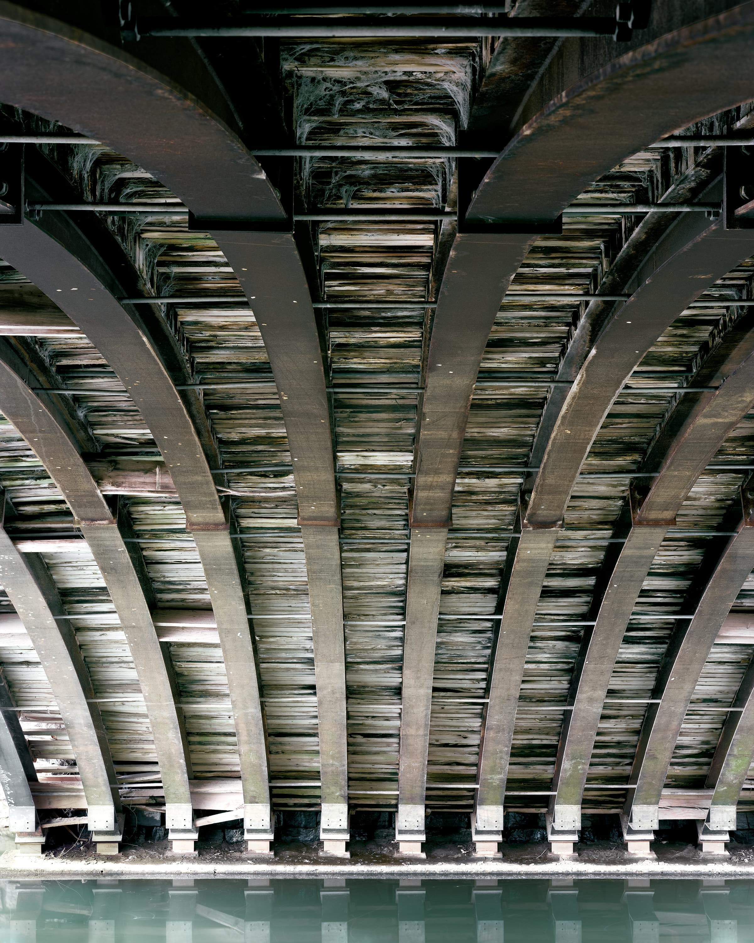 Wood-lined arched interior of stone arch bridge.